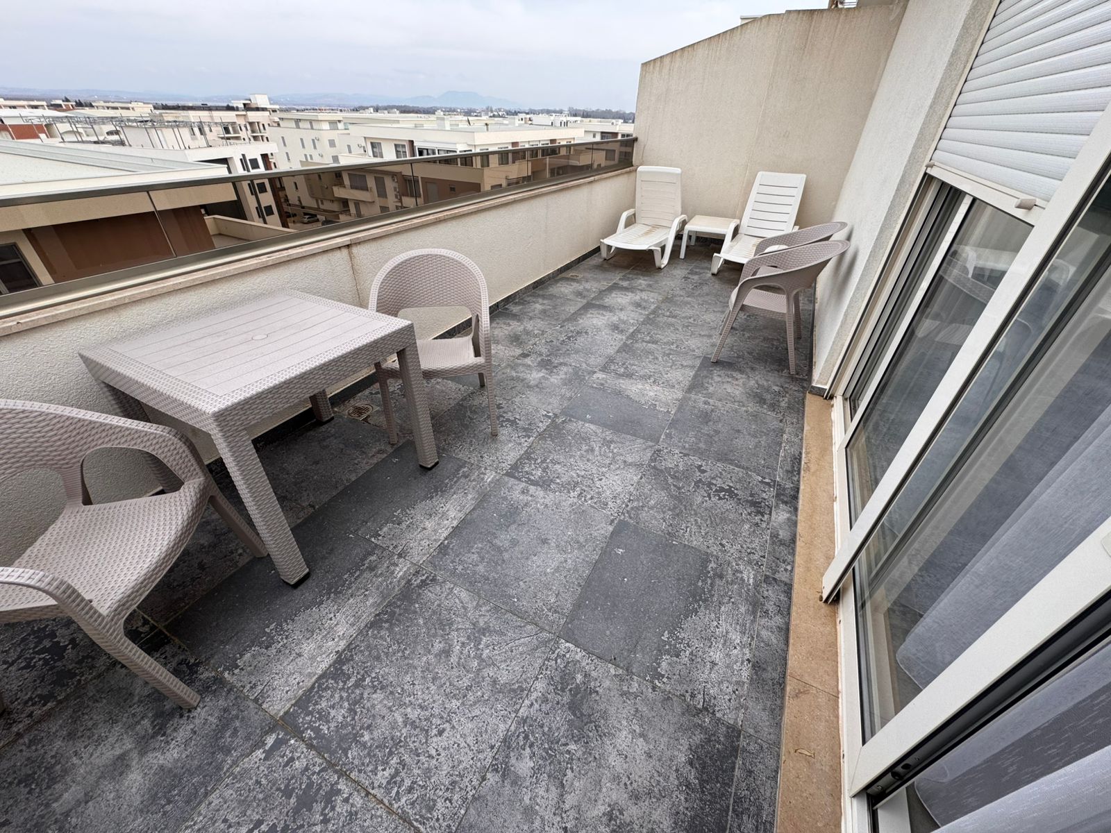 Luxurious rooftop terrace in Ulcinj with modern gray tile, ample seating, and scenic views&mdash;your top investment via montenegro-listings.me.