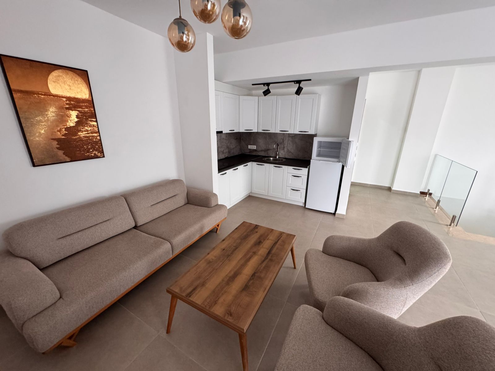 Stylish Ulcinj apartment for sale: bright living room, elegant beige sofa, kitchen with modern appliances. Invest via montenegro-listings.me by ekosphere doo.