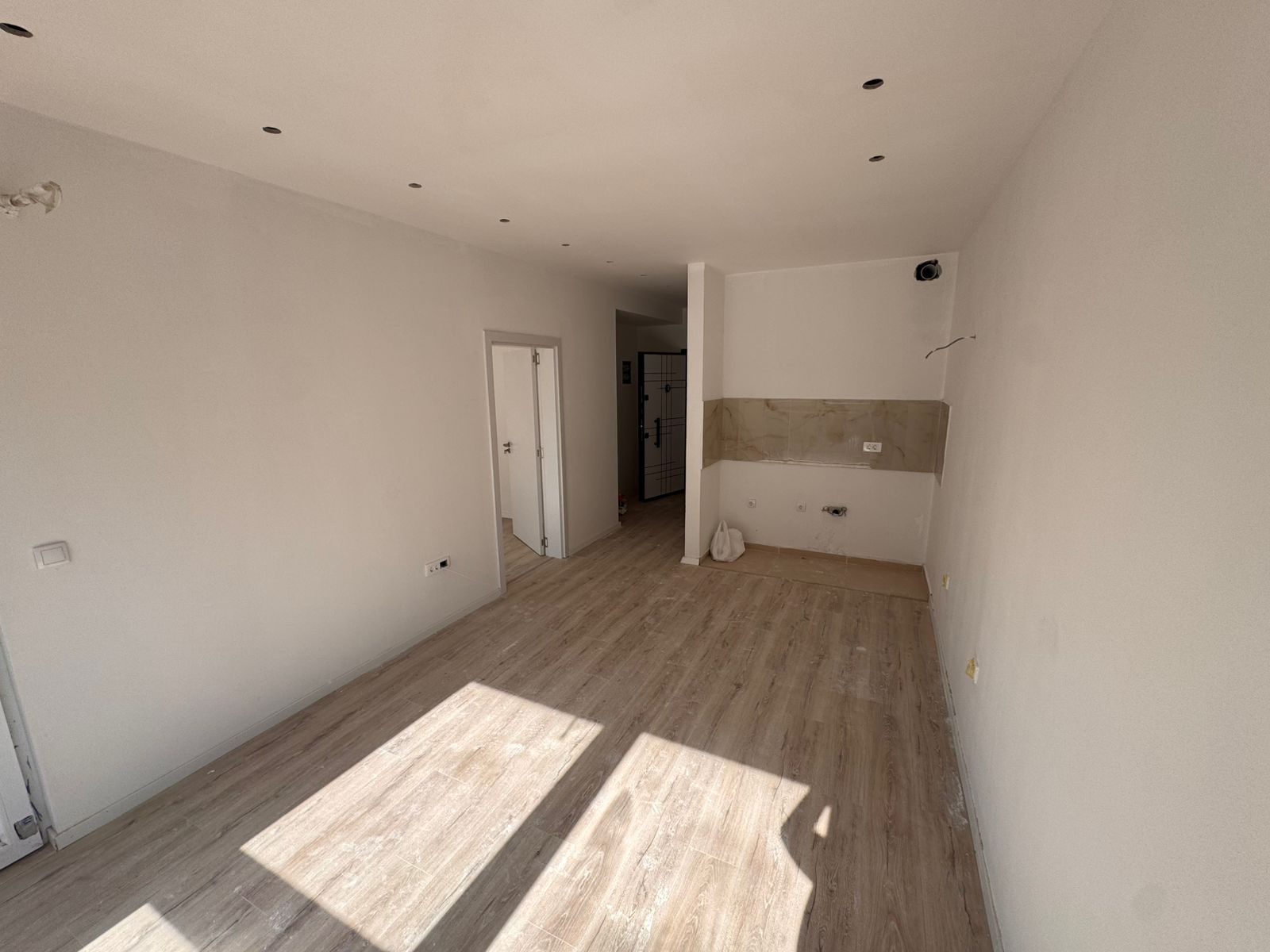 Bright unfurnished Ulcinj apartment with light wood floors, white walls, kitchen area; ideal investment on montenegro-listings.me by ekosphere doo.