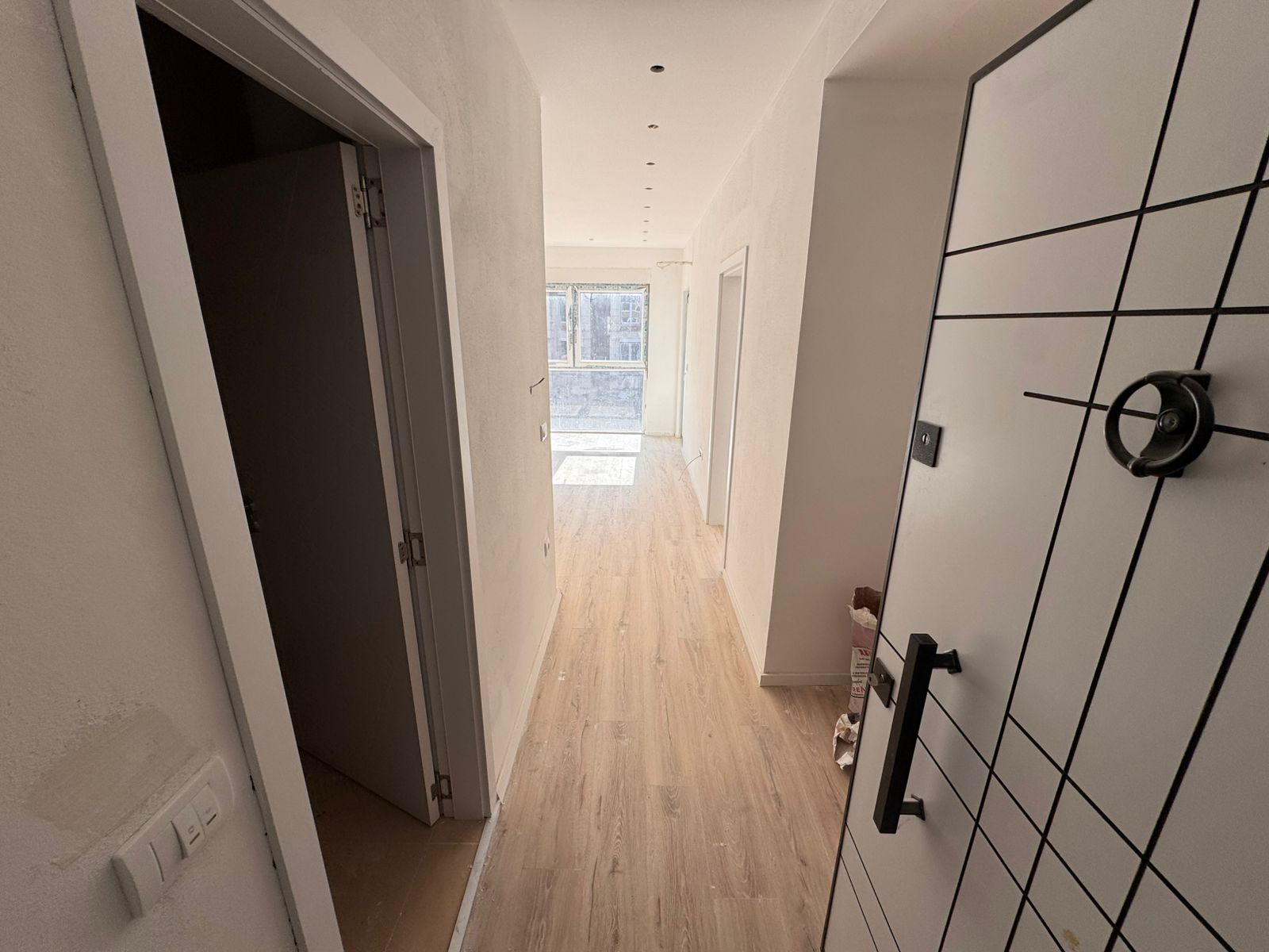 Modern hallway in Ulcinj property with light wood floors, white walls, and bright windows&mdash;exclusive via montenegro-listings.me, by ekosphere doo.