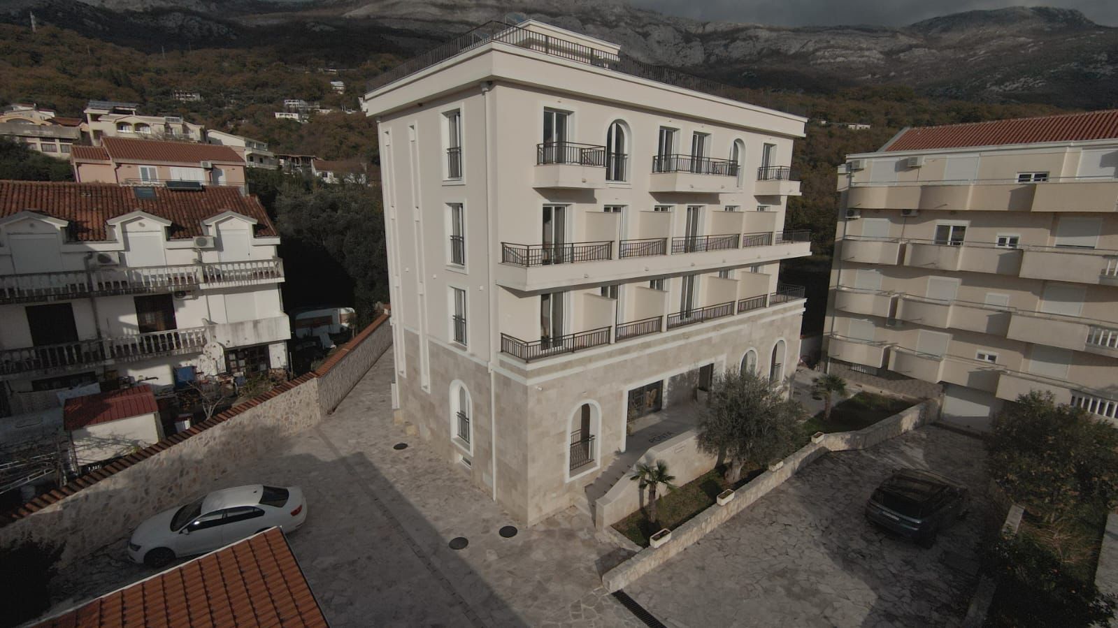Modern four-story residential building with private balconies, parking, and scenic hillside views in Ulcinj. Exclusive at montenegro-listings.me by ekosphere doo.