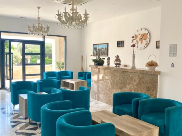 Elegant lounge in Ulcinj with teal armchairs, marble floors, chandeliers; prime real estate on montenegro-listings.me by ekosphere doo.