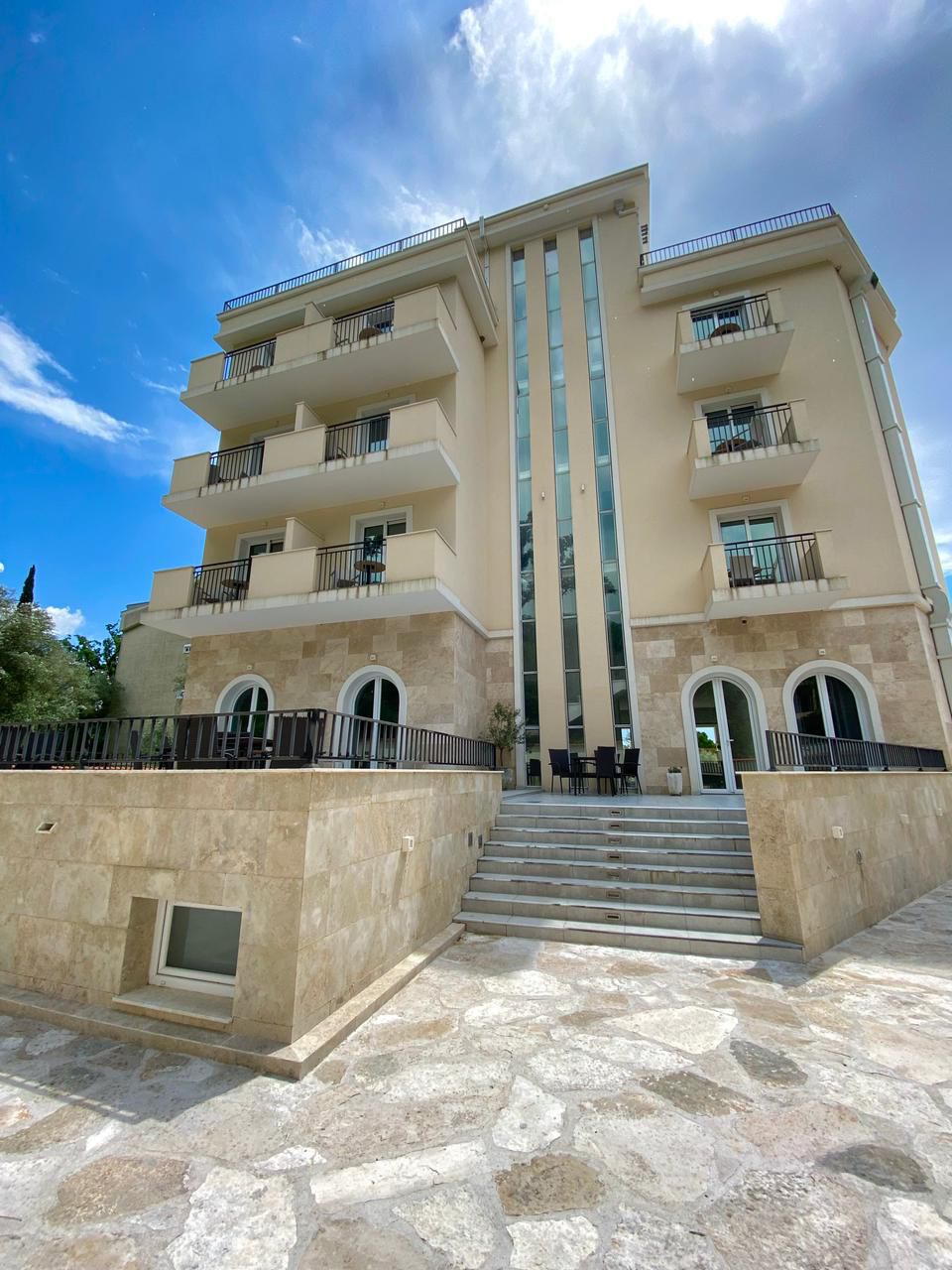 Elegant four-story property in Ulcinj, Montenegro featuring balconies, stone steps, and arched doors. Exclusive at montenegro-listings.me by ekosphere doo.