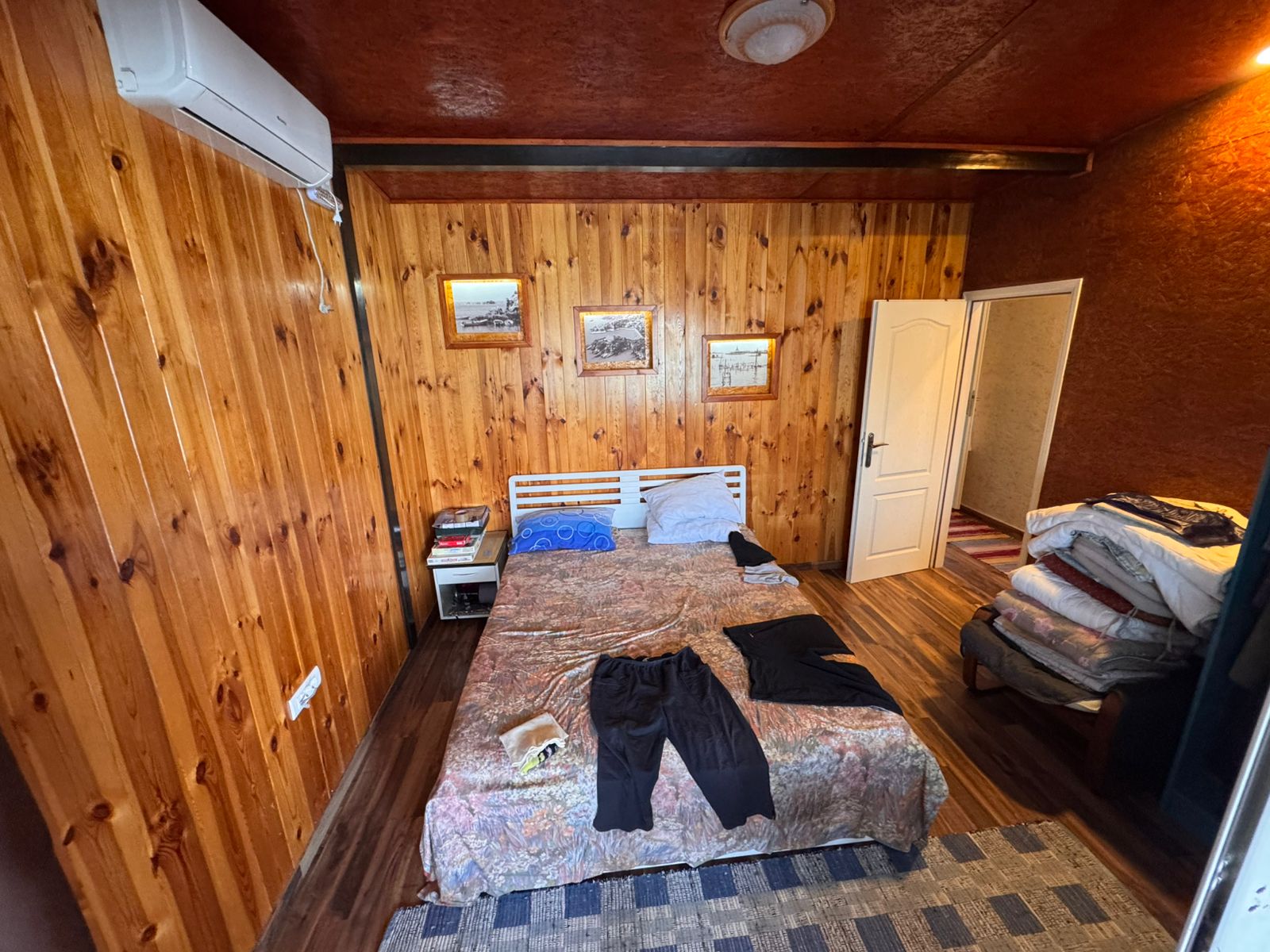 Charming Ulcinj bedroom with wood-paneled walls, stylish bed, decor accents&mdash;ideal Montenegro investment on montenegro-listings.me.