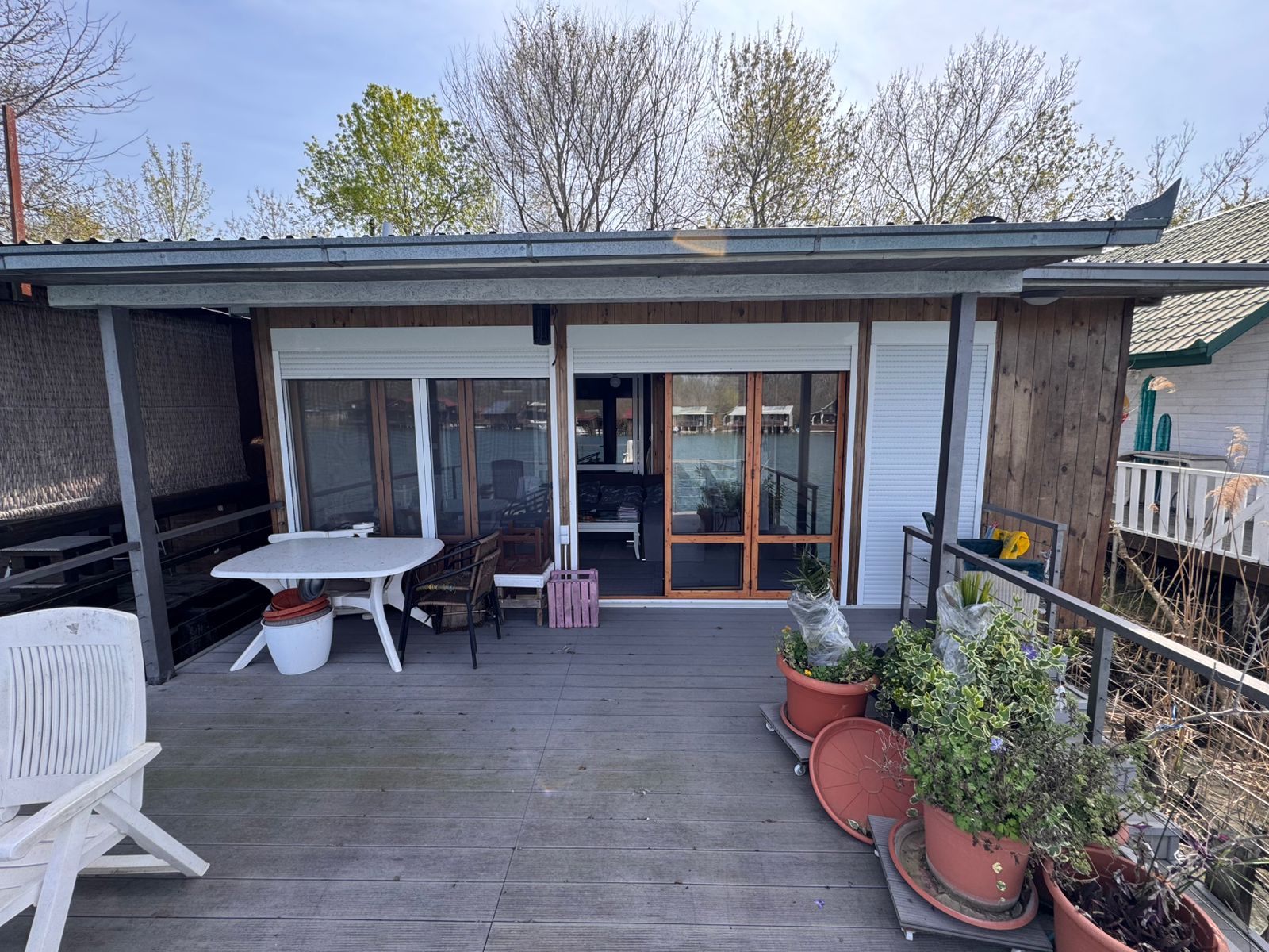 Charming Ulcinj home for sale: wooden deck, potted plants, glass doors&mdash;ideal Montenegro investment on montenegro-listings.me.