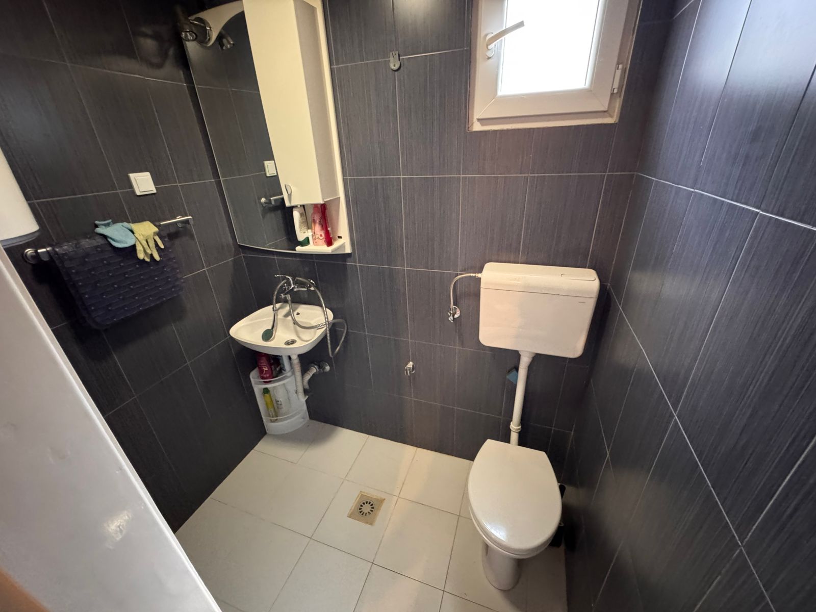 Modern bathroom with stylish gray tiles, quality fixtures, window lighting; prime Ulcinj real estate by montenegro-listings.me/Ekosphere doo.