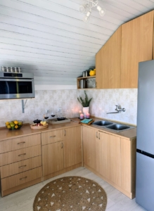 Modern Ulcinj kitchen: light wood cabinets, stainless sink, gray fridge—ideal Montenegro investment. Exclusive at montenegro-listings.me.