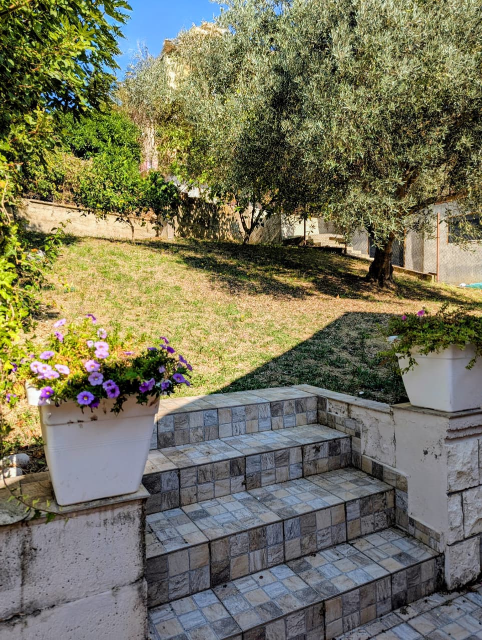 Elegant stone steps ascend to a sunlit, landscaped garden in Ulcinj, Montenegro&mdash;an ideal real estate investment at montenegro-listings.me.