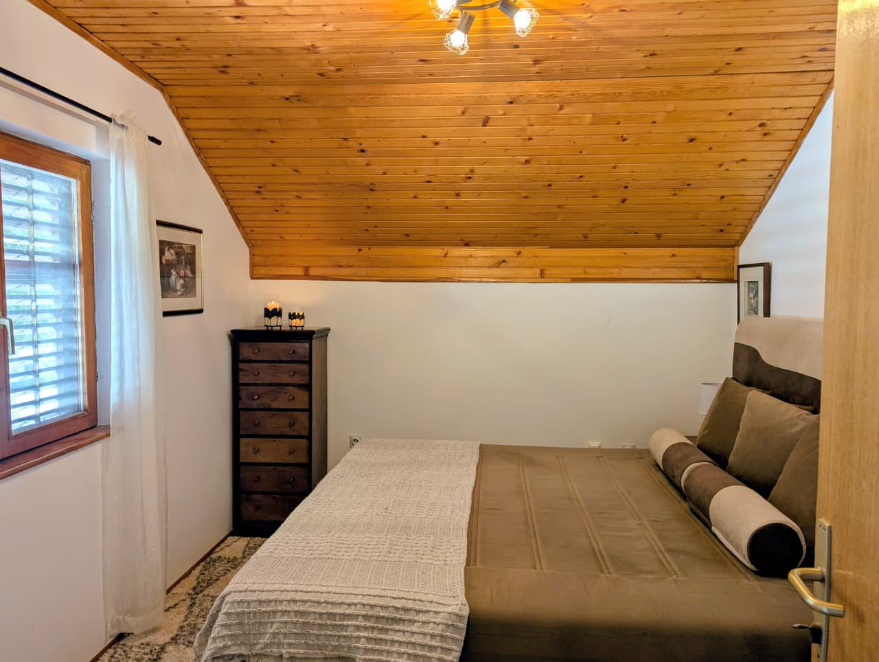 Elegant Ulcinj bedroom with sloped wood ceiling, spacious bed, modern decor; prime property investment via montenegro-listings.me by ekosphere doo.