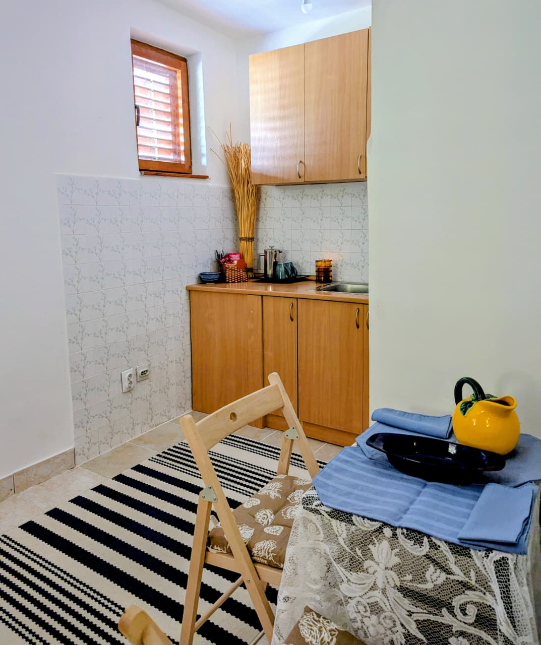 Charming Ulcinj kitchen with light wood cabinets, stylish tile, and natural light&mdash;an ideal Montenegro investment by ekosphere doo.