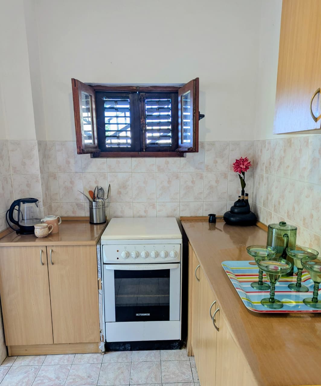 Charming Ulcinj kitchen with light wood cabinets, modern stove, open window, and elegant details&mdash;prime investment on montenegro-listings.me by ekosphere doo.