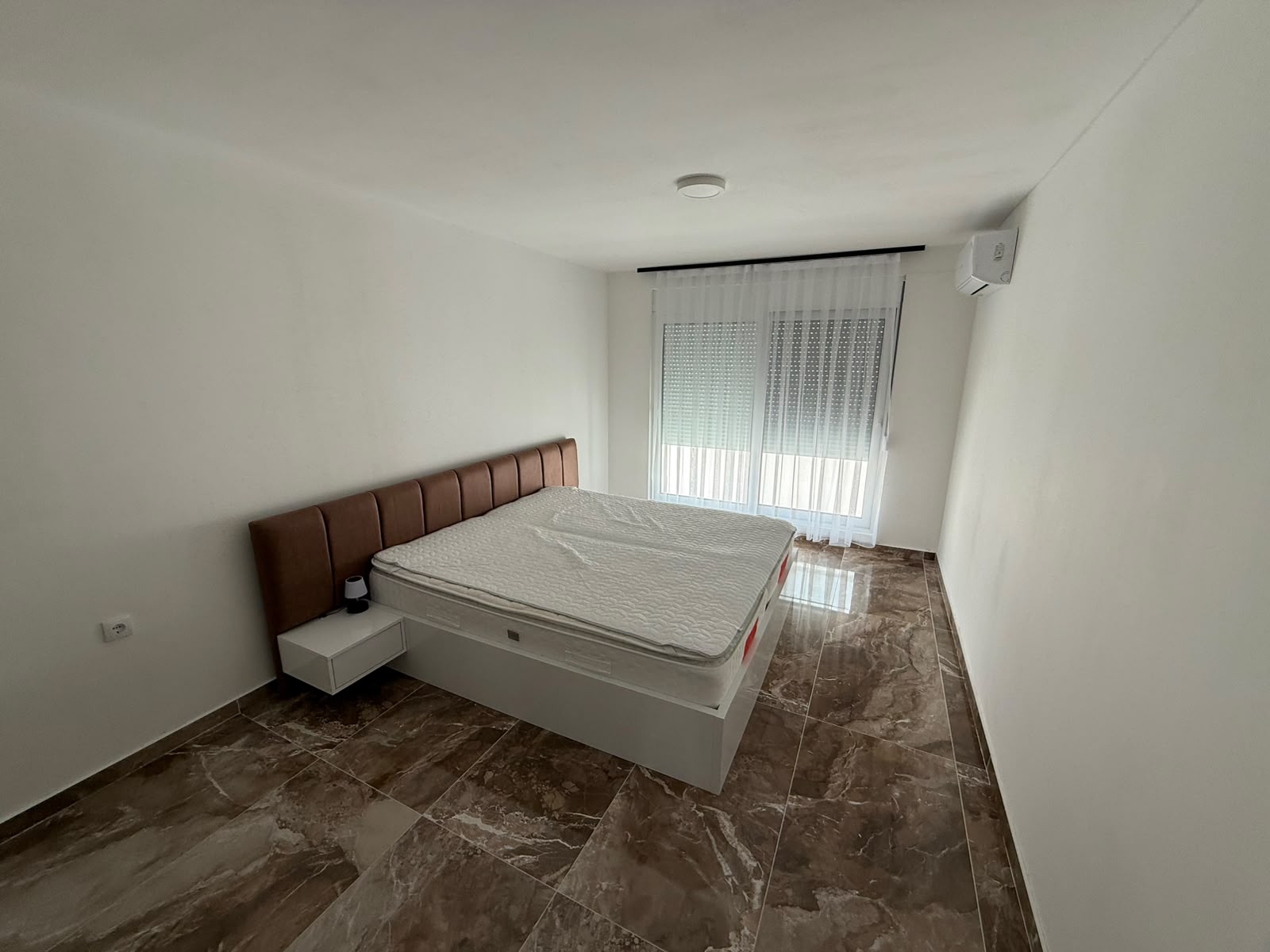 Stylish minimalist bedroom in Ulcinj with marble floors, AC, large windows. Prime investment via montenegro-listings.me by ekosphere doo.