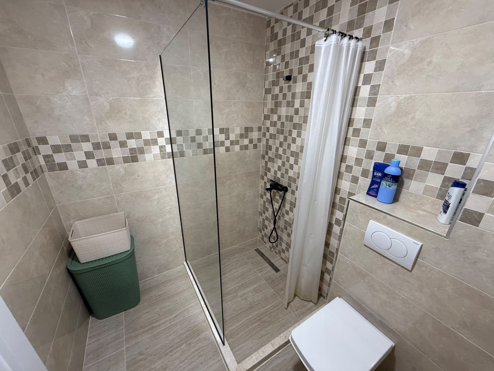 Modern bathroom in Ulcinj with beige tiles, glass walk-in shower, wall-mounted toilet&mdash;ideal real estate on montenegro-listings.me by ekosphere doo.