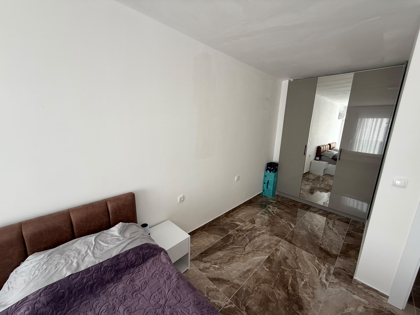 Bright Ulcinj bedroom with brown marble floors, elegant bed, mirrored closets&mdash;prime investment via montenegro-listings.me by ekosphere doo.