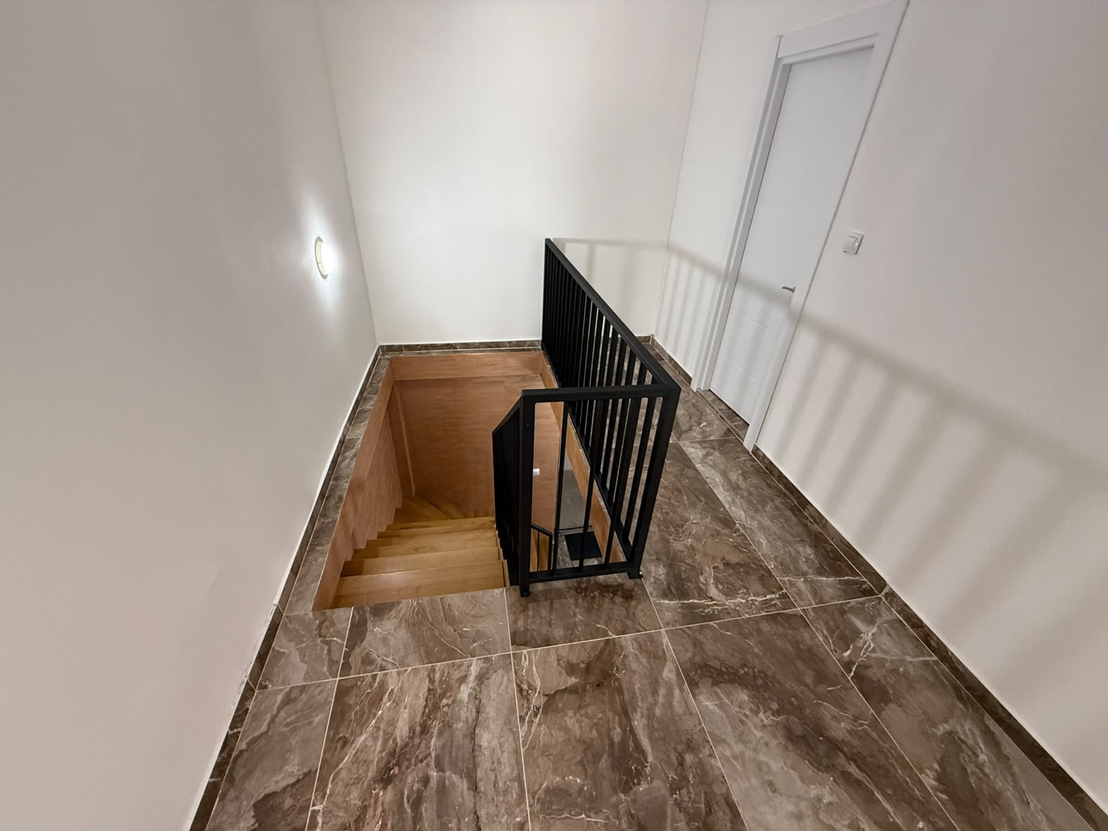 Elegant staircase with wooden steps, modern black railings, and sleek finishes&mdash;perfect Ulcinj investment via montenegro-listings.me.