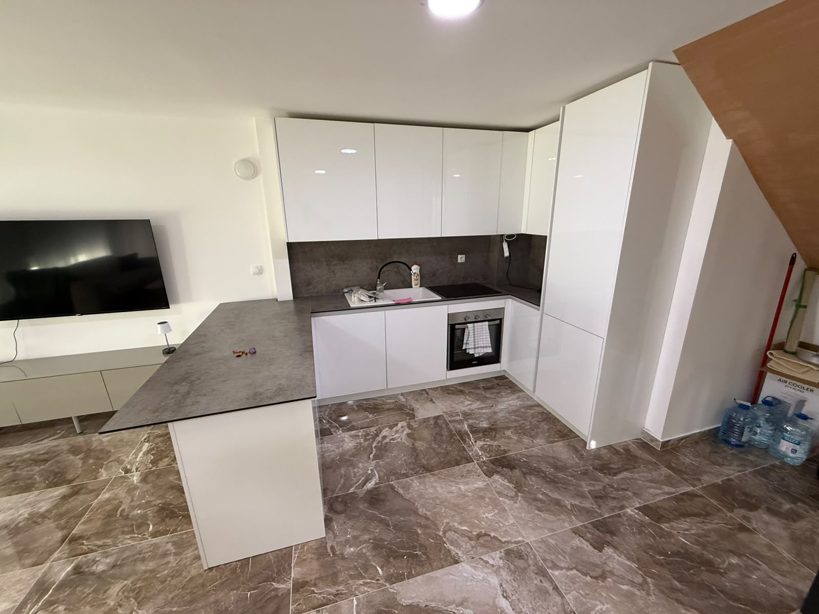 Modern Ulcinj kitchen: sleek white cabinets, built-in oven, grey countertop, marble floors. Exclusive at montenegro-listings.me, Ekosphere doo.