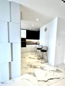 Elegant modern kitchen in Ulcinj with white cabinets, marble floors, built-in appliances—prime property via montenegro-listings.me.