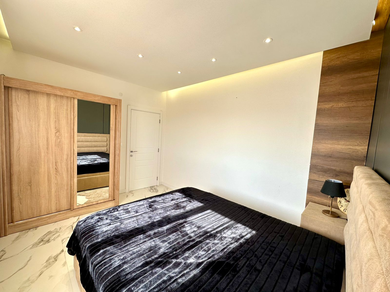Stunning Ulcinj bedroom: marble floors, recessed lighting, modern wardrobe, designer bed&mdash;exclusive property by montenegro-listings.me.