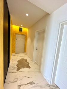 Elegant hallway in Ulcinj with white marble floors, designer rug, modern doors, premium lighting. Exclusive at montenegro-listings.me by ekosphere doo.