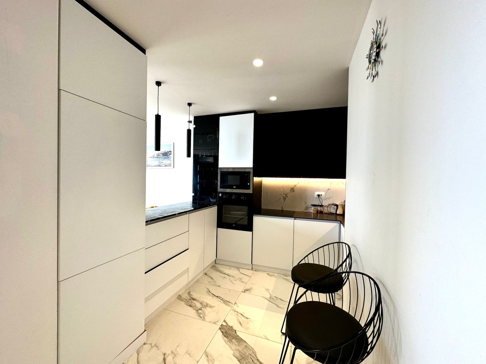 Stylish Ulcinj kitchen with white cabinetry, marble floors, modern appliances&mdash;prime Montenegro investment via montenegro-listings.me by ekosphere doo.