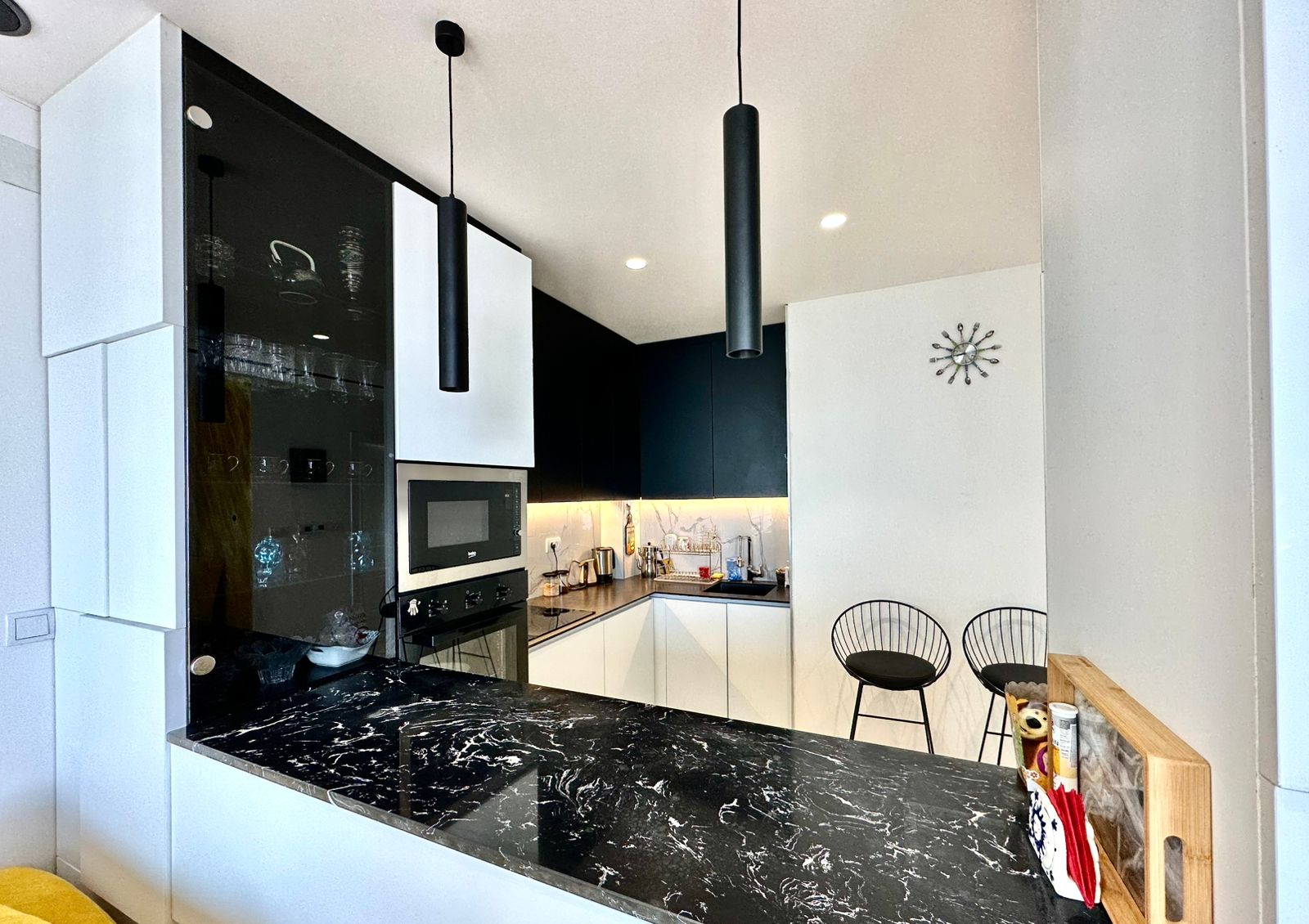 Contemporary Ulcinj kitchen with sleek black-white cabinetry, marble countertops, built-ins; invest via montenegro-listings.me by ekosphere doo.