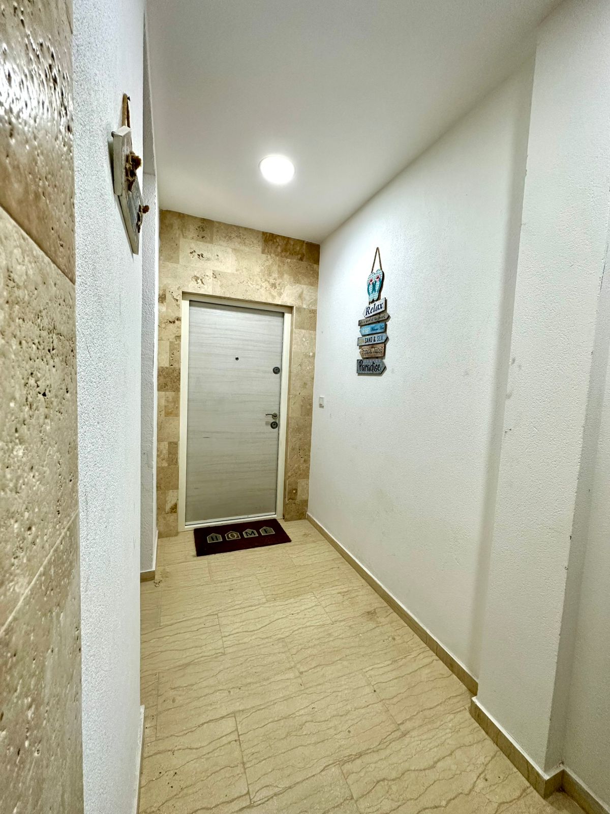 Bright hallway with elegant beige tile, pristine white door, and stylish d&eacute;cor&mdash;ideal Ulcinj property. eksosphere doo, montenegro-listings.me.