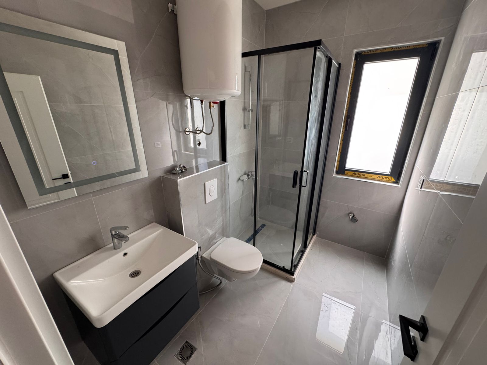 Contemporary bathroom in Ulcinj, Montenegro with stylish gray tiles, premium fixtures, and investment potential&mdash;montenegro-listings.me by ekosphere doo.