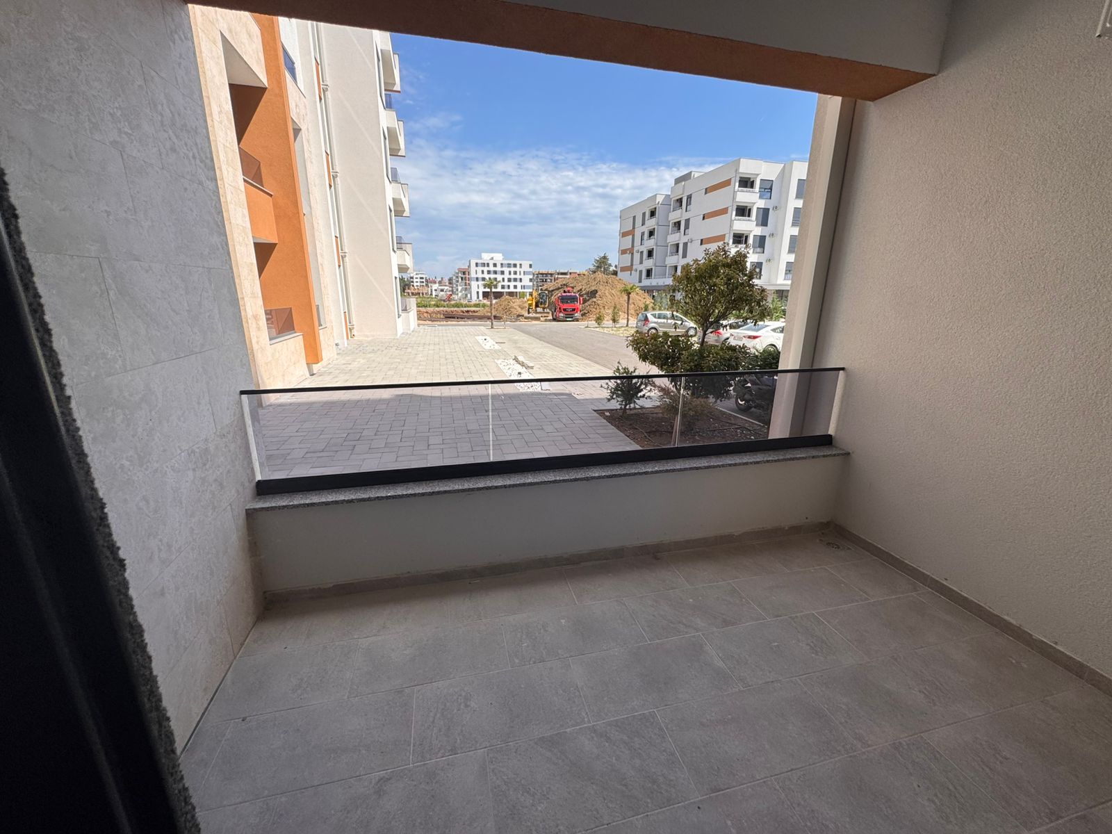 Spacious covered balcony with stylish tiles, overlooking modern Ulcinj apartments&mdash;ideal Montenegro investment via montenegro-listings.me.