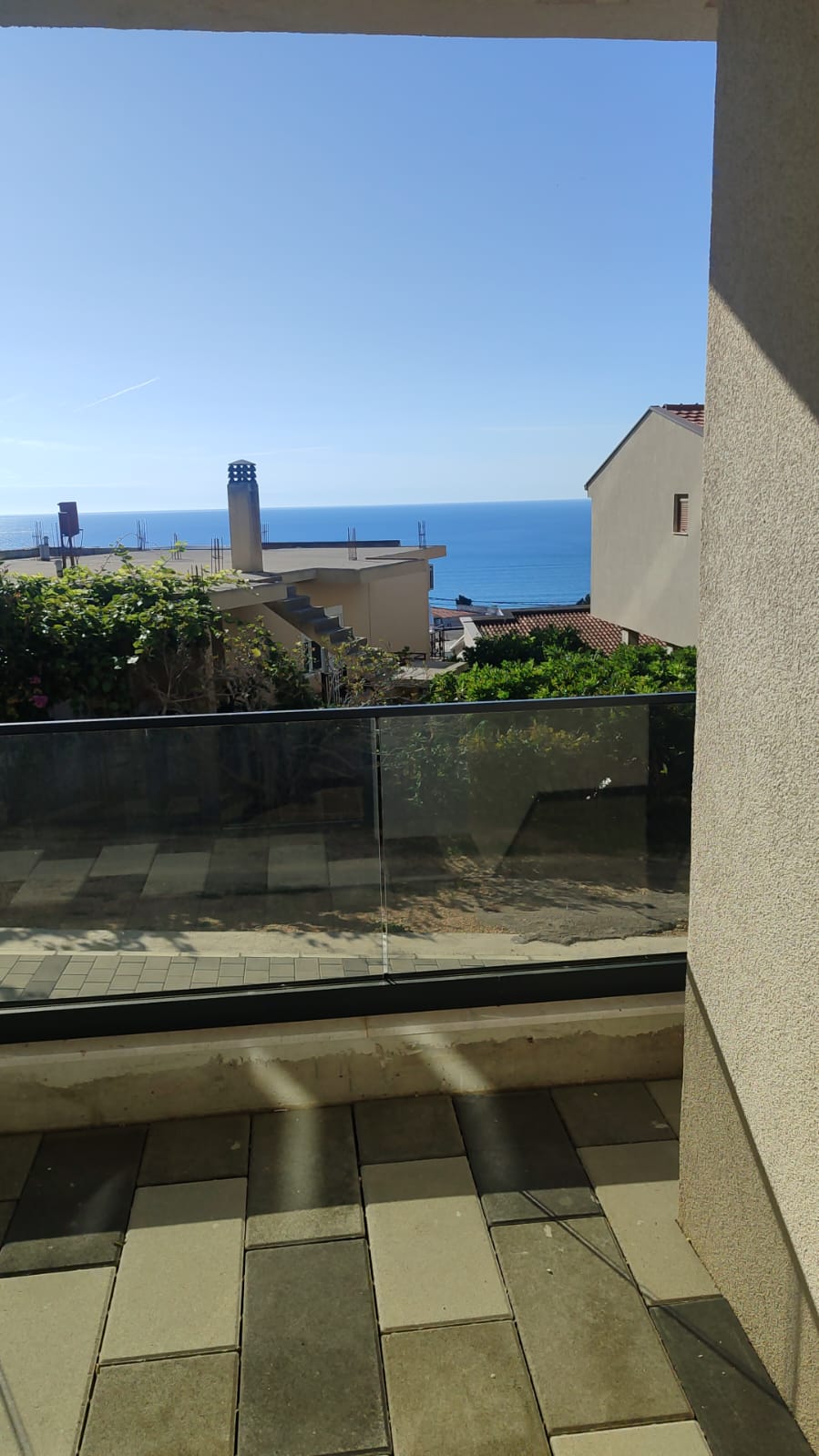 Experience breathtaking sea views from this exquisite tiled patio, framed by elegant glass railings and bathed in natural sunlight. Overlooking charming buildings with classic red roofs and lush greenery, this exclusive Ulcinj property offers serene coastal living under a vibrant blue sky. Ideal for discerning investors seeking prime real estate in Montenegro, this opportunity is featured on montenegro-listings.me—a project by ekosphere doo Ulcinj—making it the perfect choice for your next investment or dream home on the Adriatic coast.