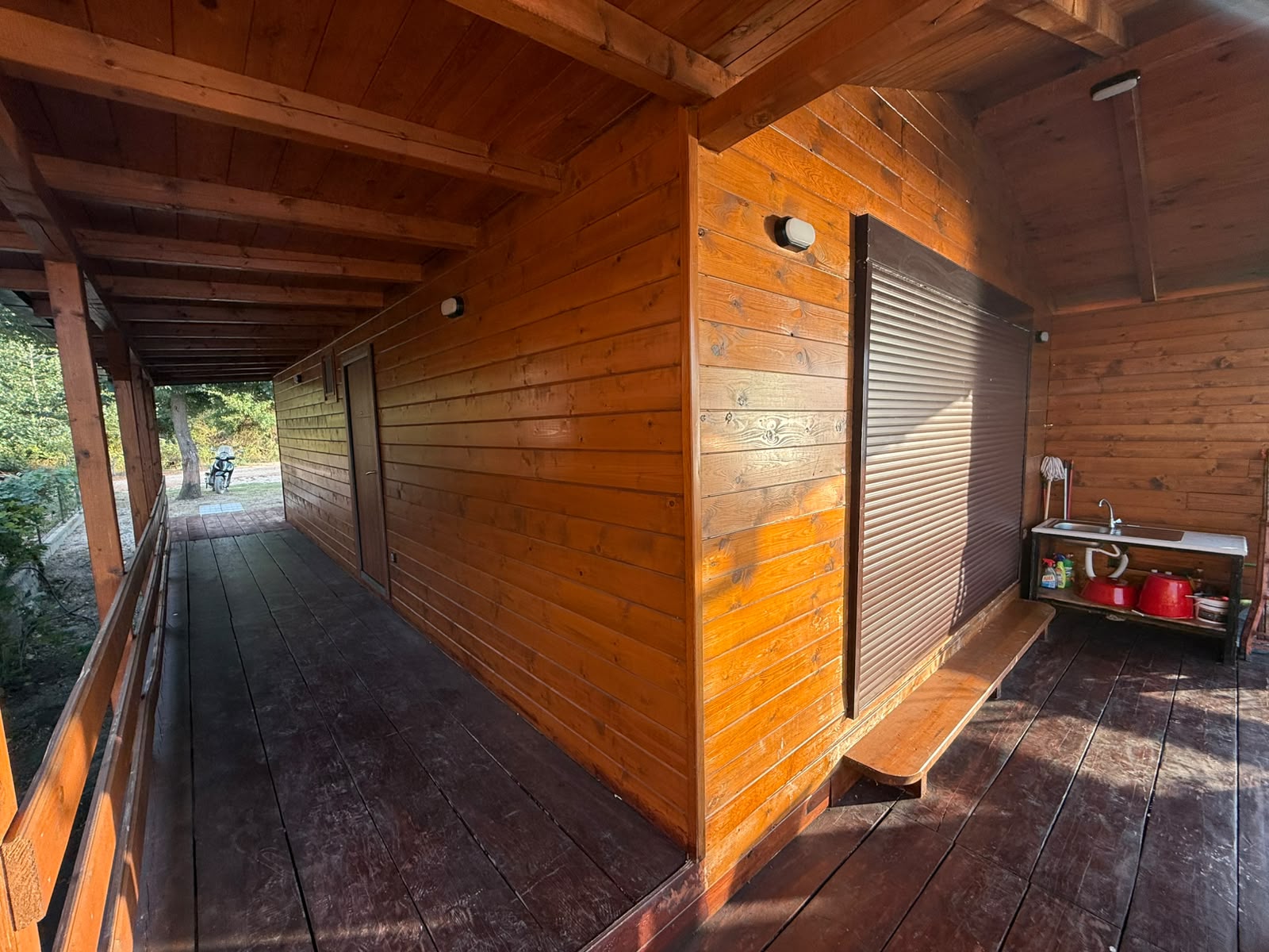 Discover your ideal investment opportunity in Ulcinj, Montenegro with this charming wooden cabin, exclusively listed on montenegro-listings.me—a project of ekosphere doo. Featuring a spacious covered porch perfect for outdoor relaxation, an elegant outdoor sink, and classic shuttered windows for added security and style. Enjoy abundant natural sunlight and serene views of mature greenery from every angle. The property includes dedicated parking space visible by the motorcycle parked along a private path, ensuring both convenience and accessibility. Seize your chance to own a unique real estate asset in the thriving Montenegro property market—request details today!.