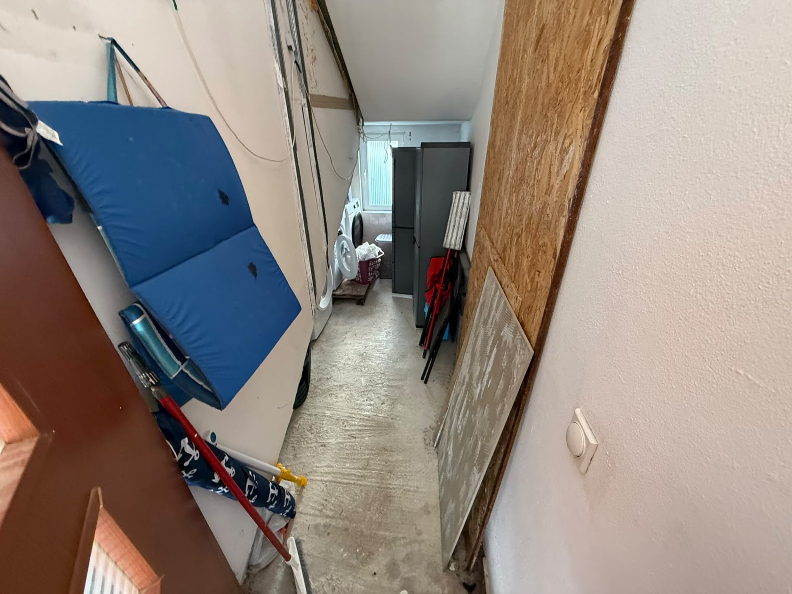 Investment opportunity in Ulcinj, Montenegro: This property features a functional utility hallway with solid concrete flooring and robust unfinished walls, offering exceptional potential for customization. The corridor is thoughtfully equipped with gym mats and secure storage space for cleaning tools, with a washing machine conveniently positioned by a bright window. Perfect for investors seeking versatile spaces to personalize, this asset highlights the value of Montenegrin real estate through montenegro-listings.me—a premier project by ekosphere doo in Ulcinj. Discover your next investment in the growing Montenegro property market today.